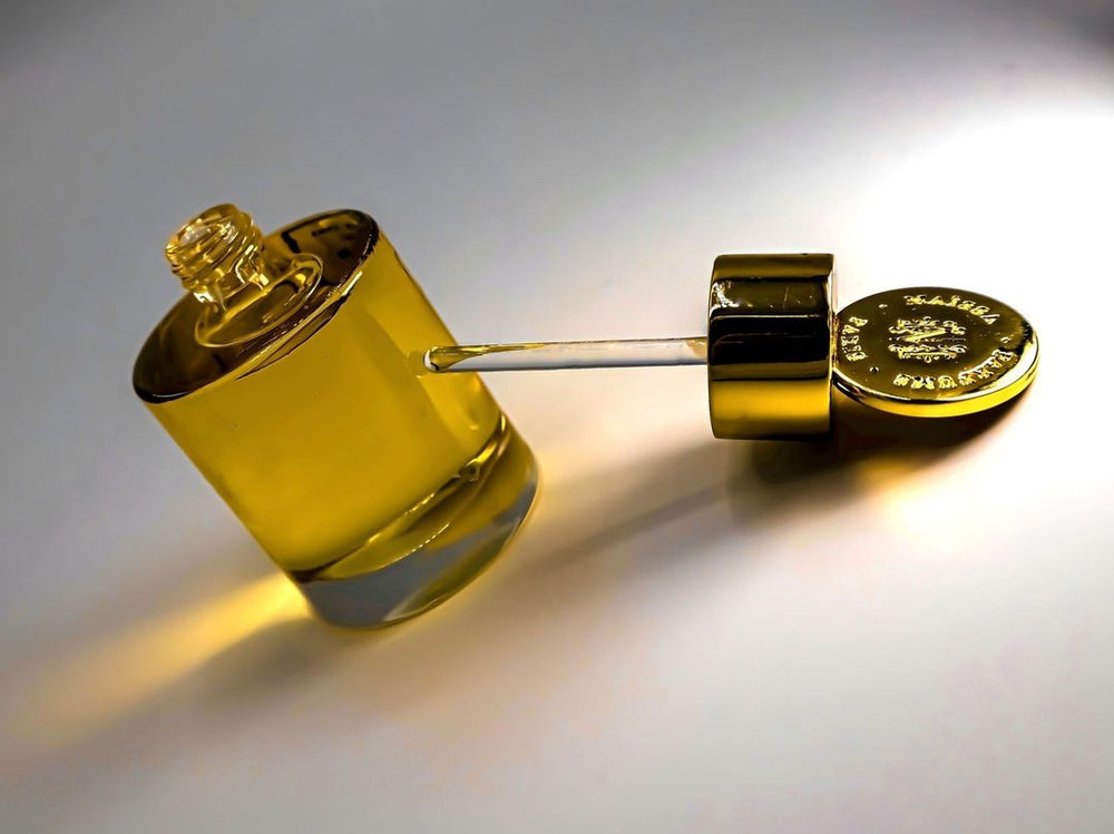 Luxurious golden perfume bottle with pipette, elegantly reflecting light, reminiscent of Maison Maïssa's or the5thscent's opulent scent.