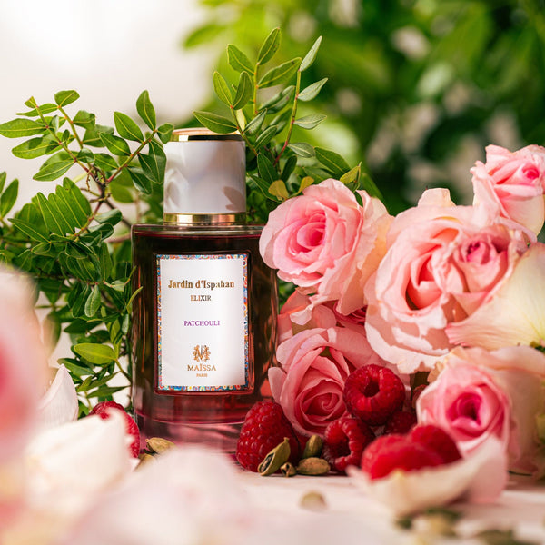Maïssa Jardin d’Ispahan Patchouli Elixir among pink roses, raspberries and green foliage