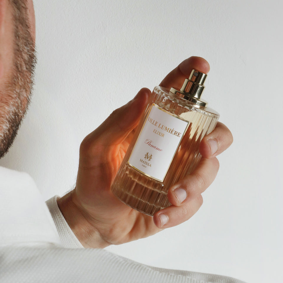 A person elegantly holding Maison Maïssa perfume bottle, capturing sophistication and luxury in an artisanal design, embodying the5thscent.