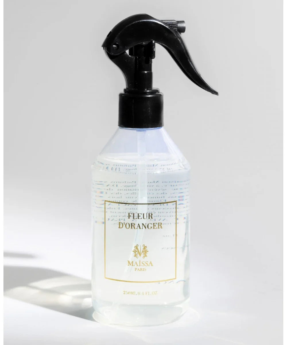 Transparent spray bottle with black trigger containing Fleur d’Oranger liquid by Maissa Paris