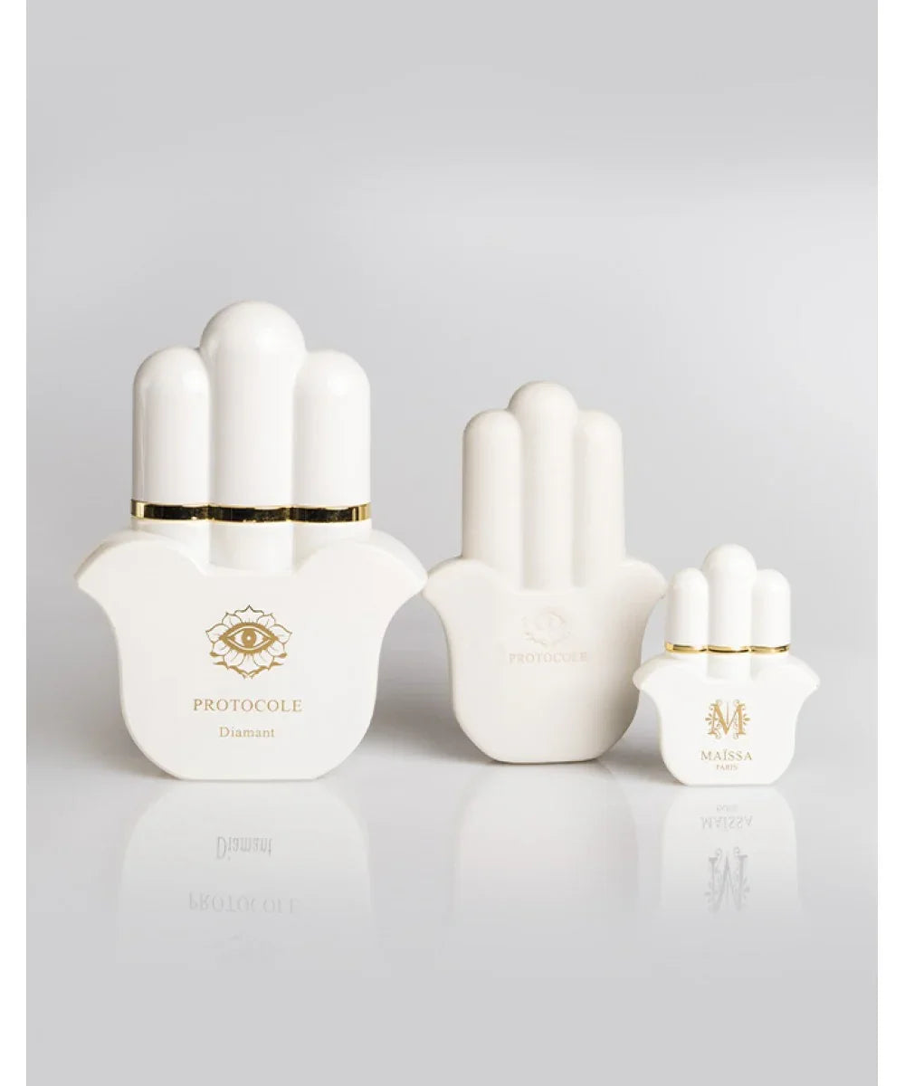 Set of white and black luxury perfume bottles and packaging shaped like a hand with gold accents and logos