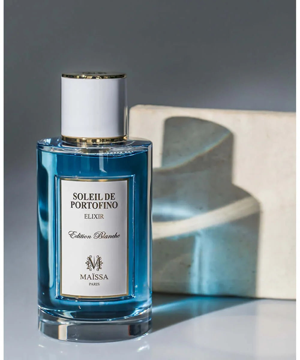 Soleil de Portofino Elixir Edition Blanche perfume bottle by Maïssa Paris with blue liquid and white gold-trimmed cap