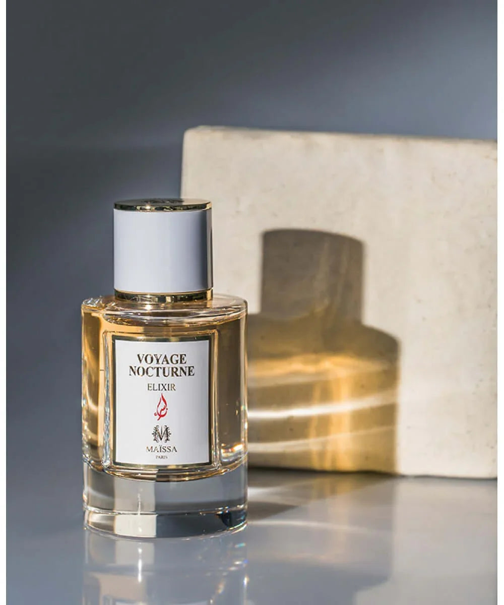 Voyage Nocturne Elixir perfume bottle by Maïssa Paris with gold accents and clear glass