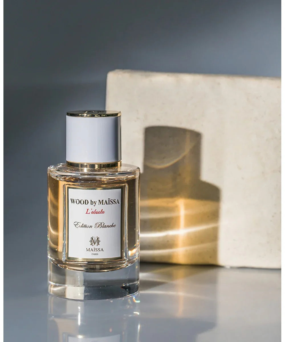 Wood by Maïssa L'absolu Edition Blanche perfume bottle with gold and white design